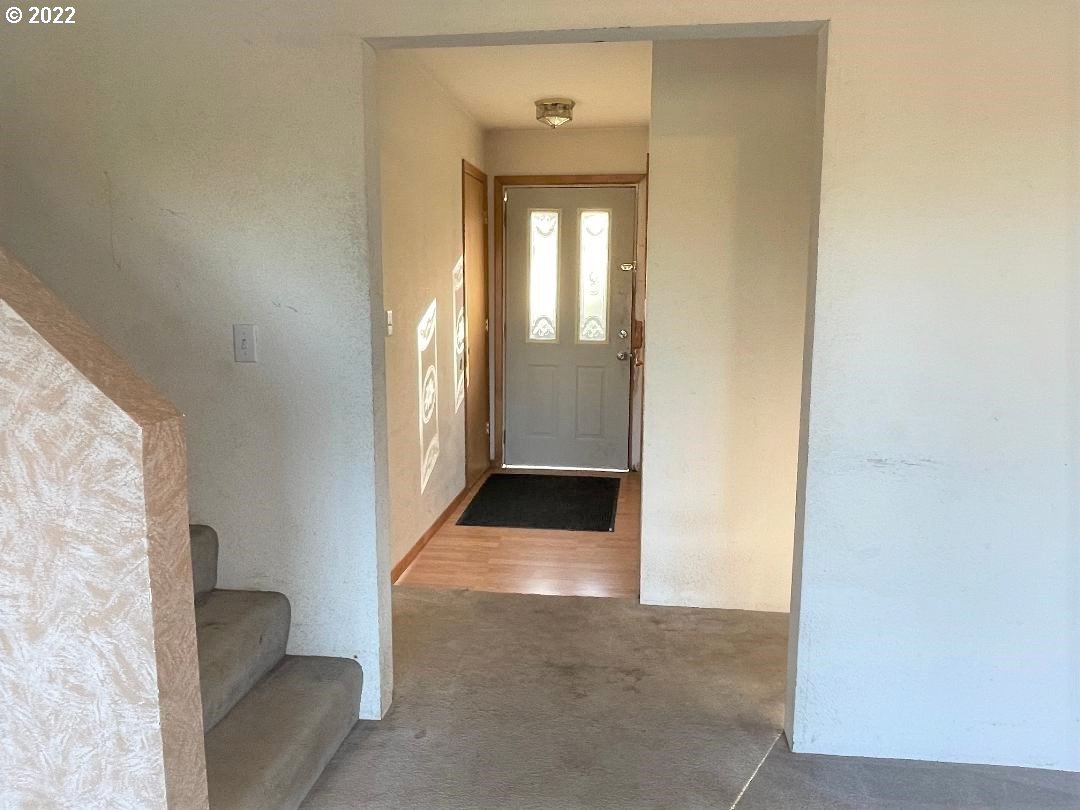 347 Huckleberry Mountain Lane Riddle, OR 97469 - Photo 8 of 32 a view of a hallway with wooden floor and a living room