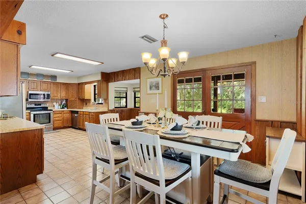 a kitchen with a sink table and chairs