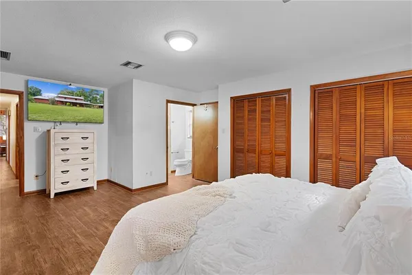 an aerial view of a house with outdoor space and trees all around