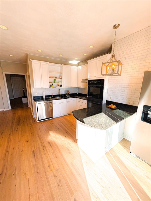 a kitchen with stainless steel appliances granite countertop a sink a stove top oven a chimney and a center island