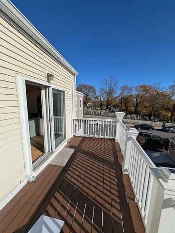 a view of a balcony with wooden floor and fence