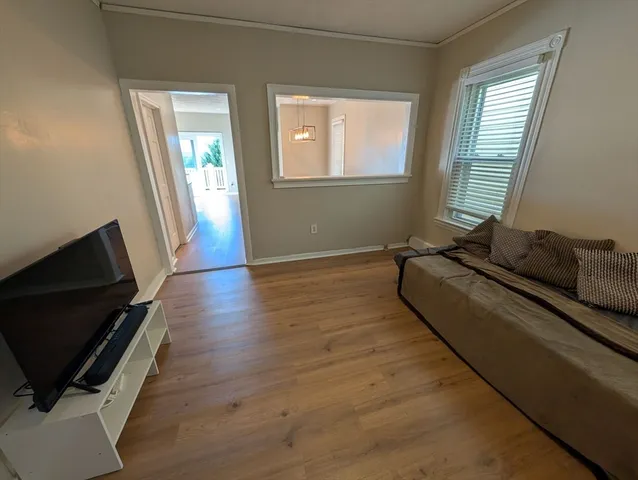 a living room with hardwood floor and a window
