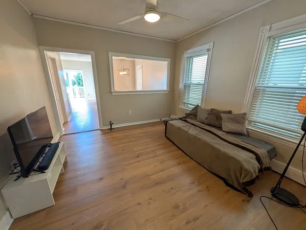 a spacious bedroom with a bed and wooden floor