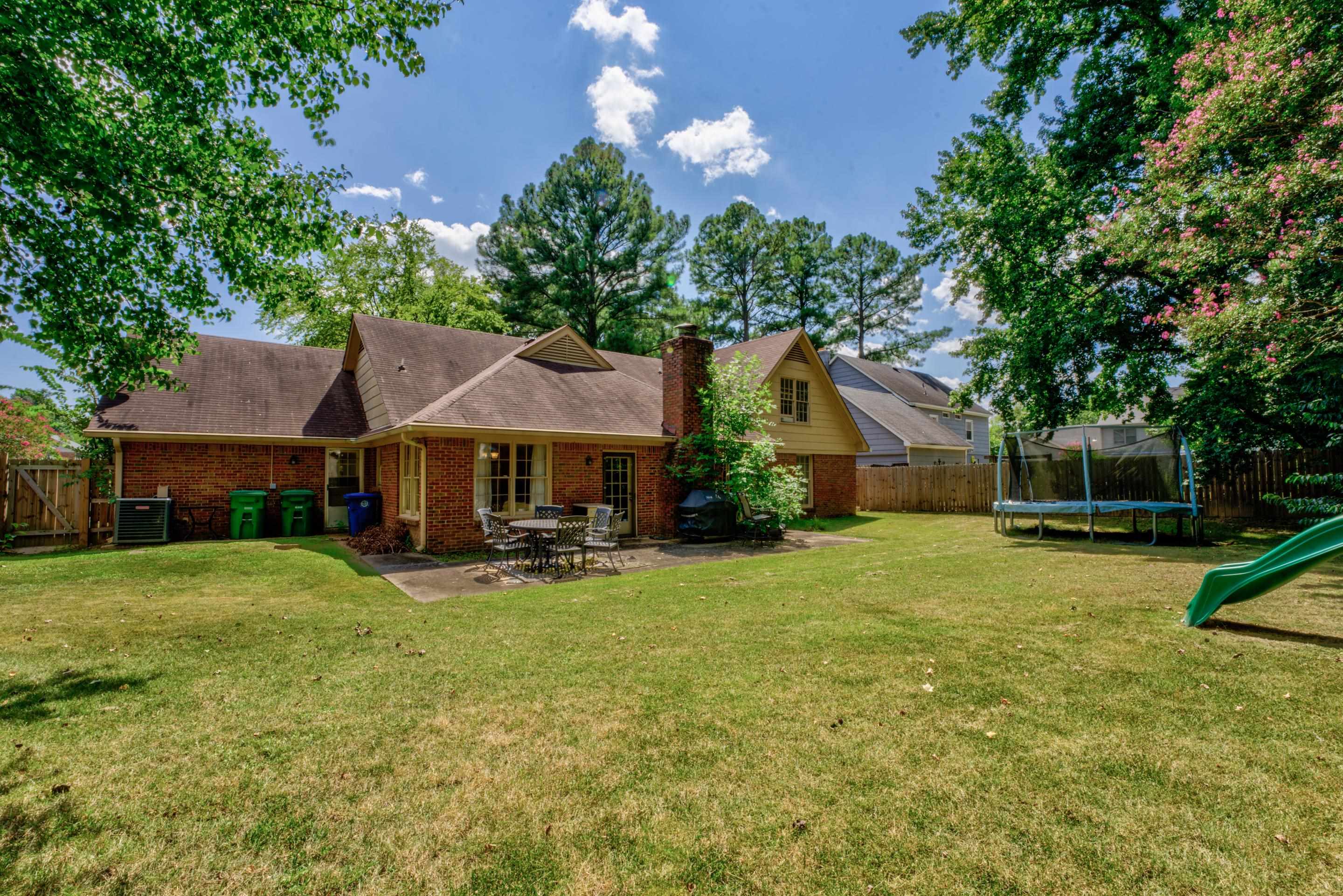 2031 Corbin Road Germantown, TN 38139 - Photo 23 of 27 Back of property with a patio area, central air condition unit, a trampoline, and a lawn