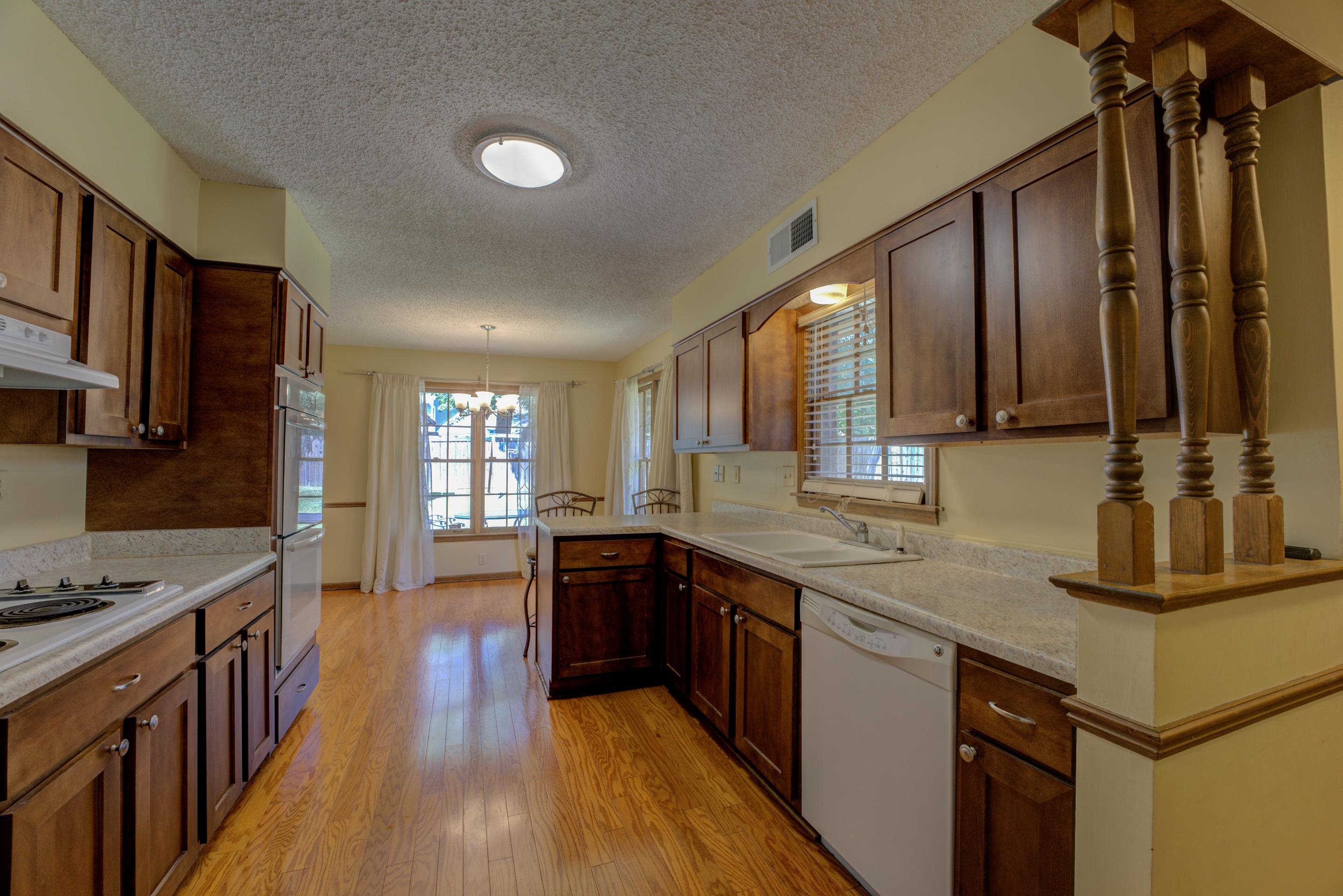 2031 Corbin Road Germantown, TN 38139 - Photo 8 of 27 Kitchen featuring sink, light hardwood / wood-style flooring, white appliances, and a healthy amount of sunlight