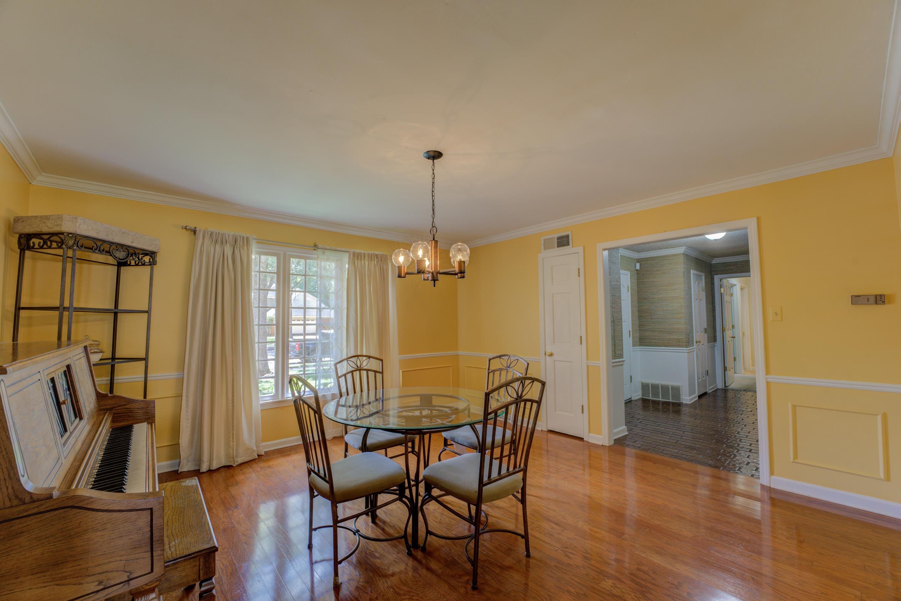 2031 Corbin Road Germantown, TN 38139 - Photo 9 of 27 Dining space featuring a notable chandelier, hardwood / wood-style floors, and crown molding