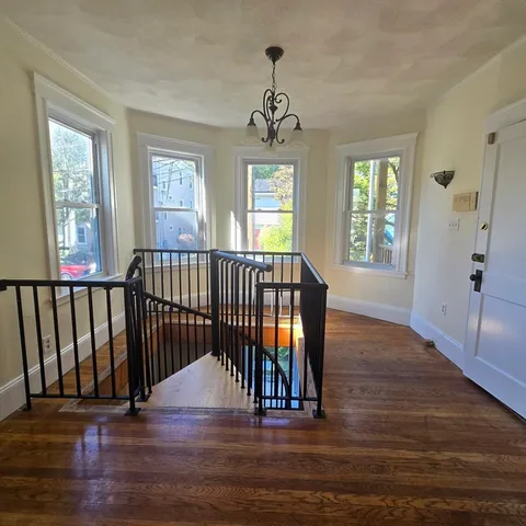 a view of entryway with wooden floor and windows