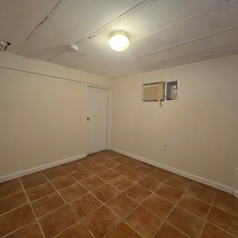 an empty room with a white wall and a window