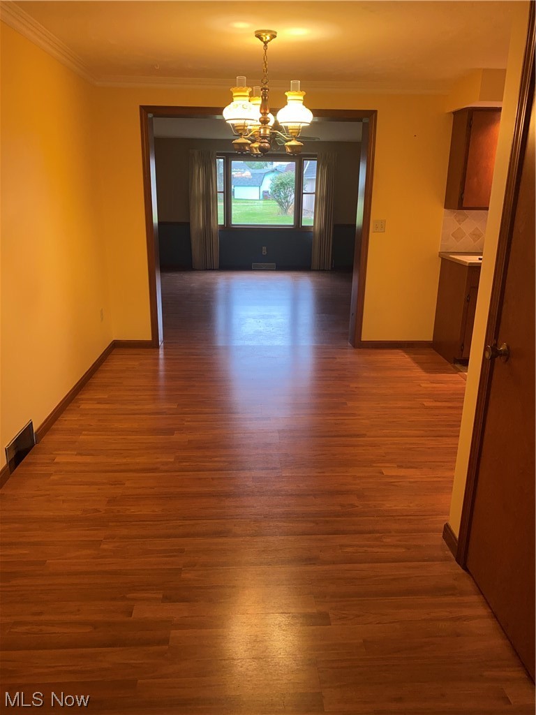 1518 Walnut Road Southwest Massillon, OH 44647 - Photo 6 of 26 Unfurnished room with dark hardwood / wood-style flooring, a chandelier, and ornamental molding