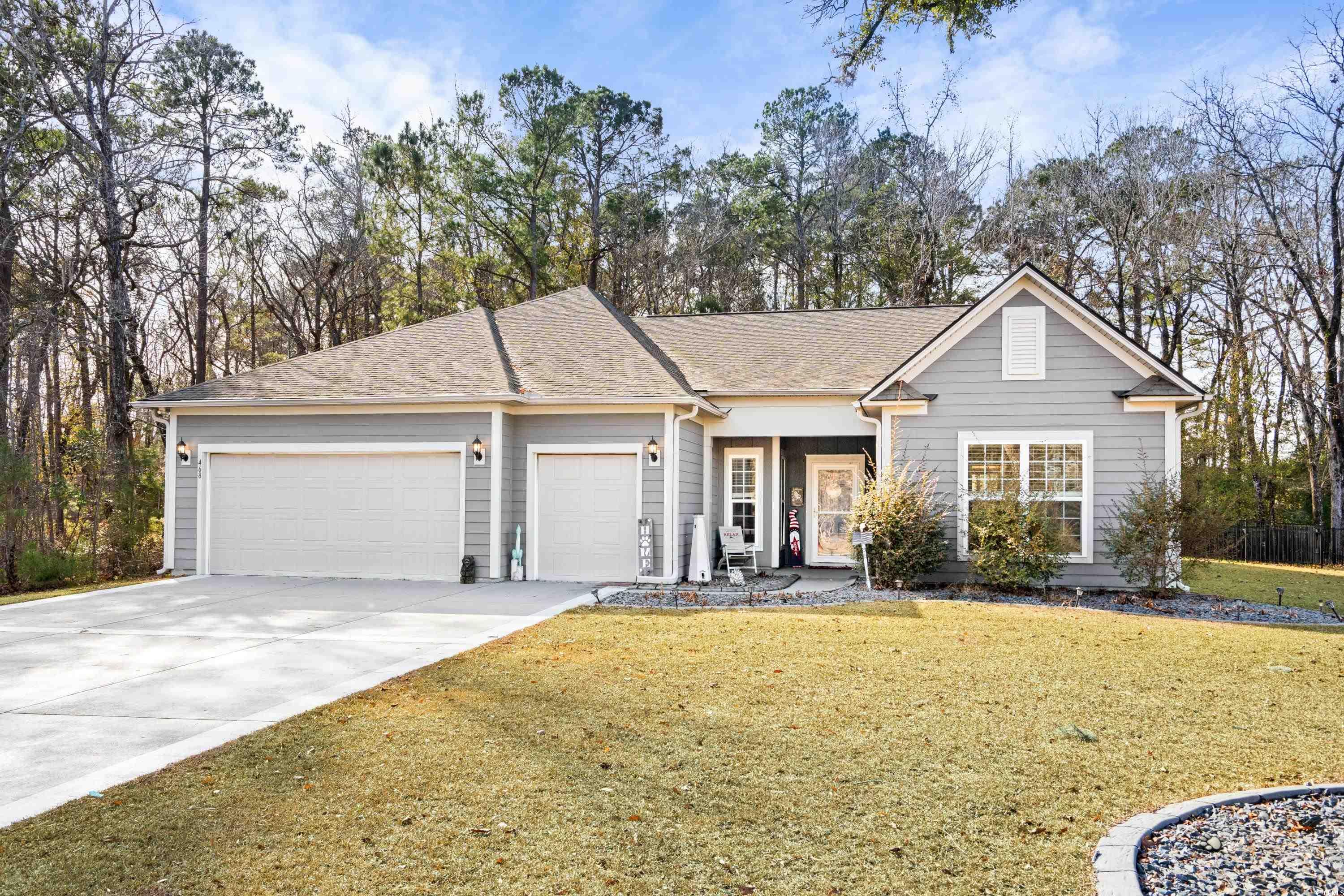 Ranch-style home featuring a front yard and a gara