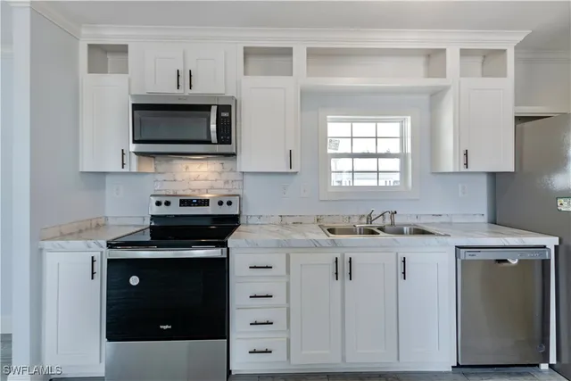 a kitchen with stainless steel appliances granite countertop a stove a sink and a microwave