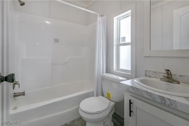 a bathroom with a granite countertop sink a toilet and a bathtub
