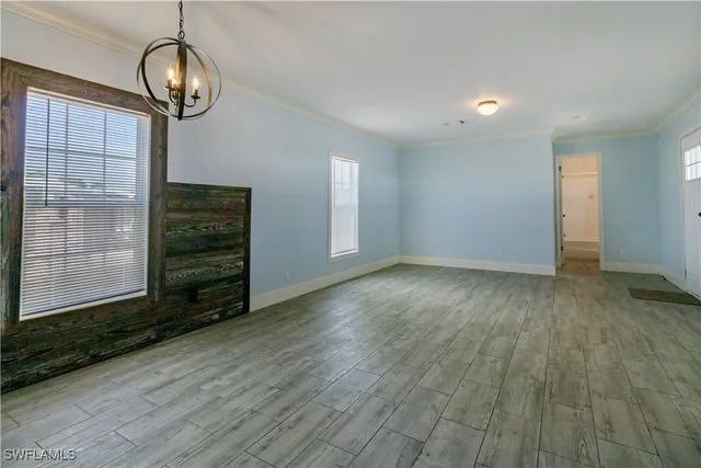 a view of a livingroom with wooden floor staircase and a chandelier