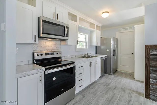 a kitchen with stainless steel appliances a stove microwave and refrigerator