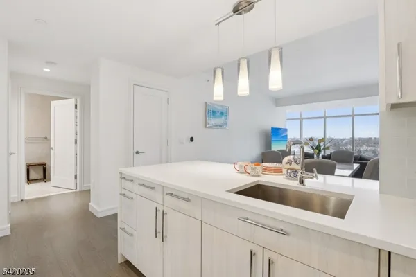 a kitchen with a sink cabinets and wooden floor