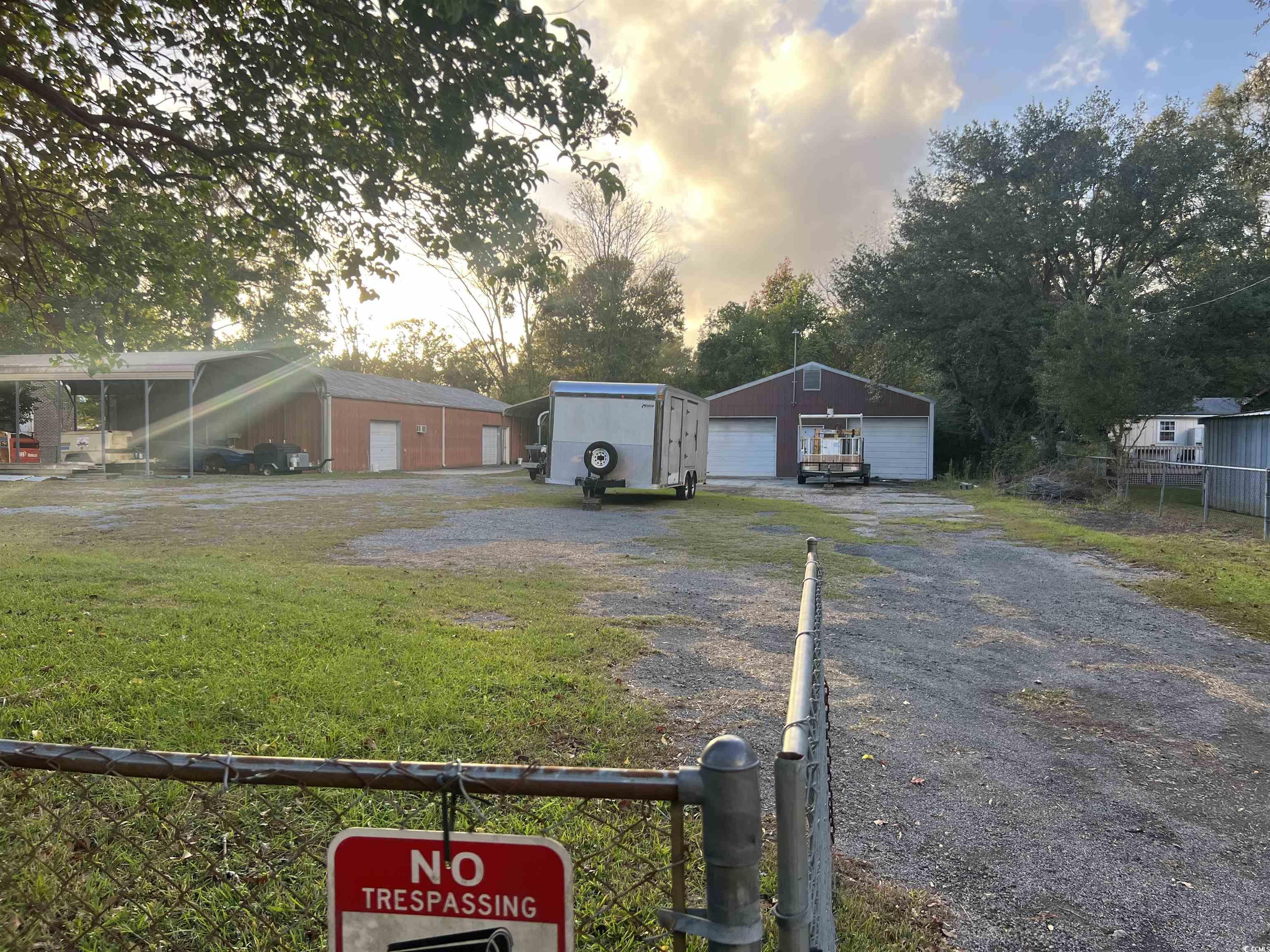 Yard at dusk with a garage and an outbuilding