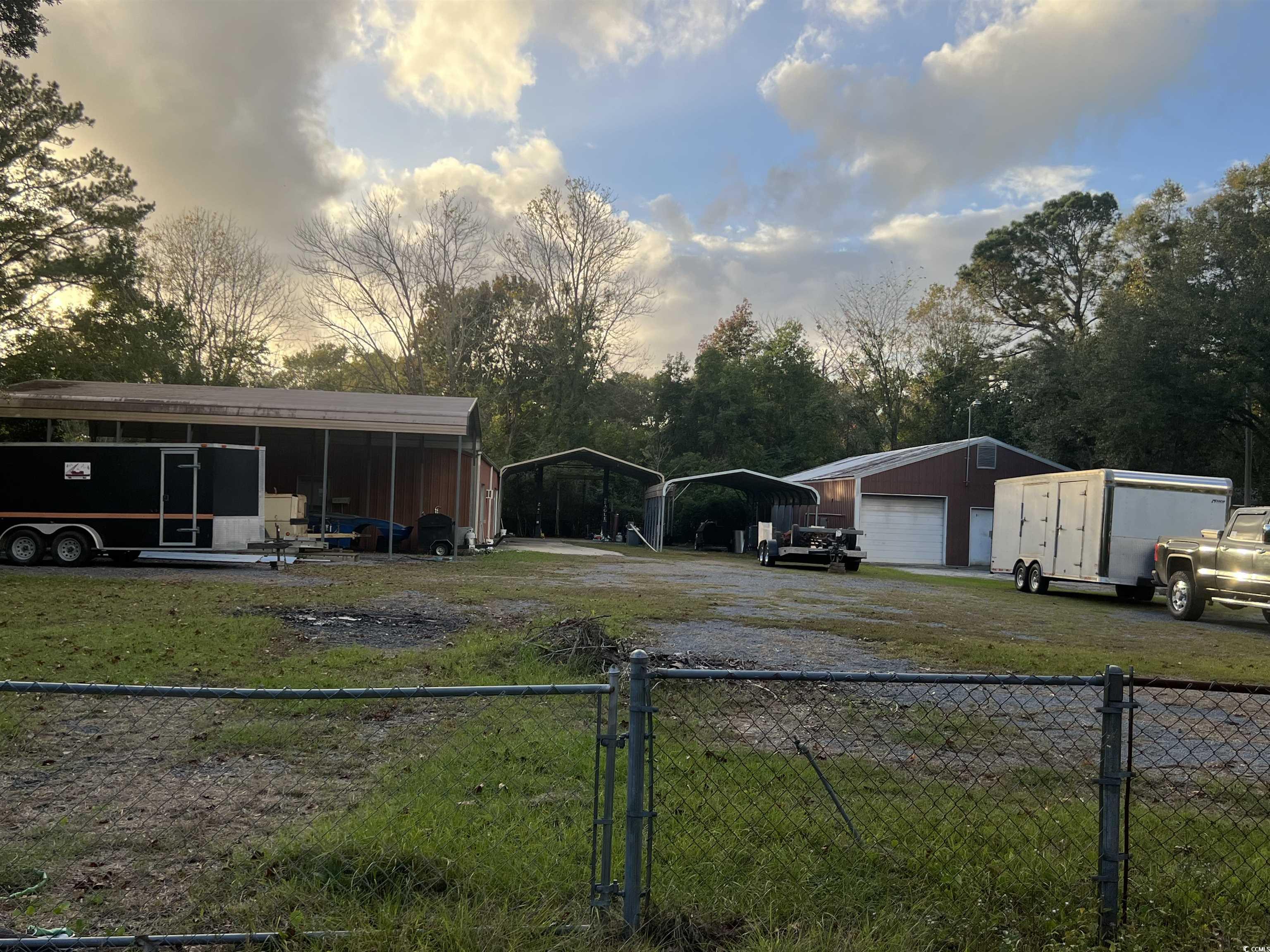 127 County Rd S-22-577 Georgetown, SC 29440 - Photo 3 of 11 Yard at dusk with an outbuilding, a carport, and a