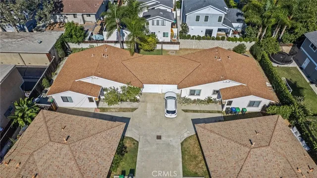 an aerial view of residential houses with outdoor space and parking
