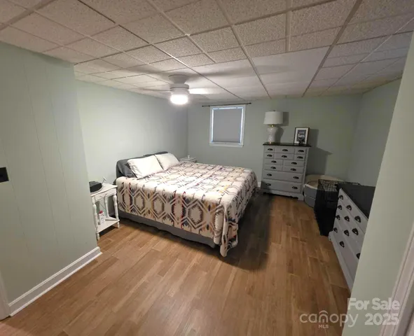 a bedroom with a bed and a wooden floor