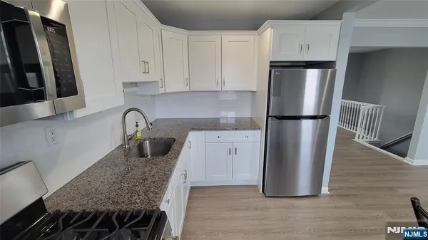 a kitchen with refrigerator and cabinets
