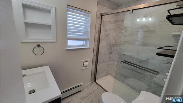 a bathroom with a shower a toilet and a sink