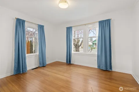 a view of a livingroom with wooden floor and windows