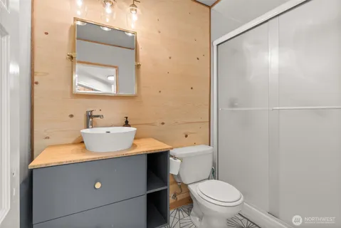 a bathroom with a sink toilet mirror and vanity