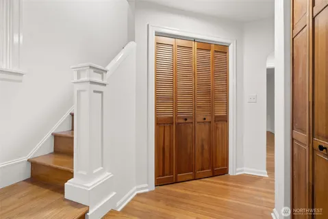 a view of a livingroom with wooden floor and a bathroom