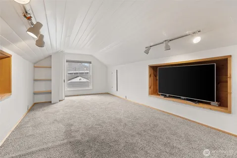 a view of an empty room with a fireplace and a window