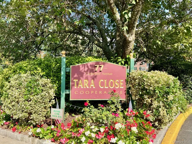 a sign that is sitting in front of flowers