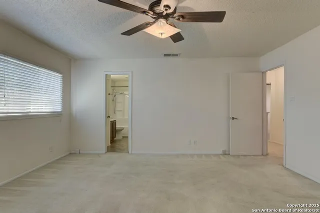 an empty room with closet and a chandelier fan