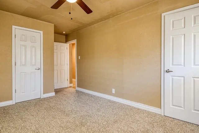 an empty room with chandelier fan