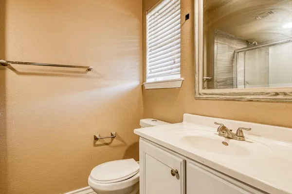 a bathroom with a sink a toilet and a mirror