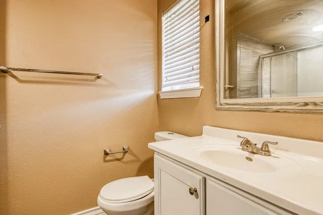 a bathroom with a sink a toilet and a mirror