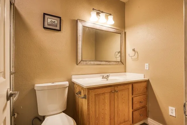 a bathroom with a toilet sink and mirror