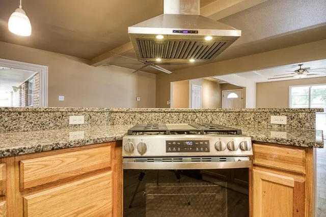 a stove top oven sitting inside of a kitchen