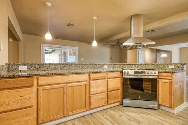a kitchen with stainless steel appliances granite countertop a stove a sink and a refrigerator