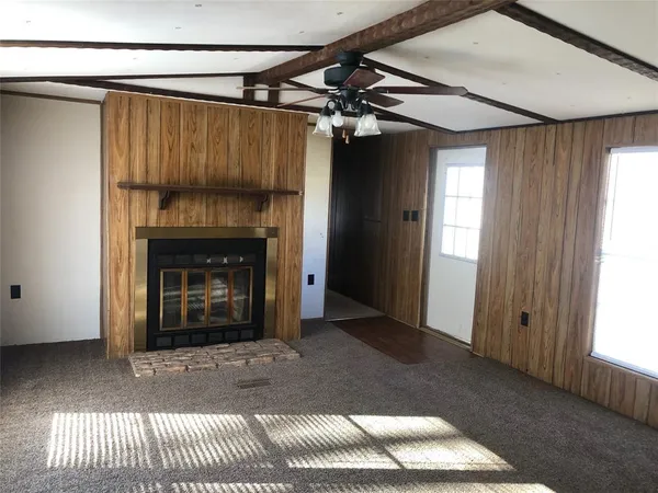 a view of a livingroom with a fireplace and window