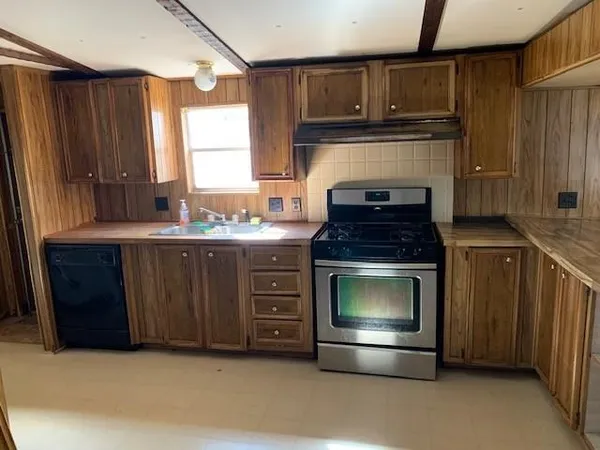 a kitchen with granite countertop a stove and a sink
