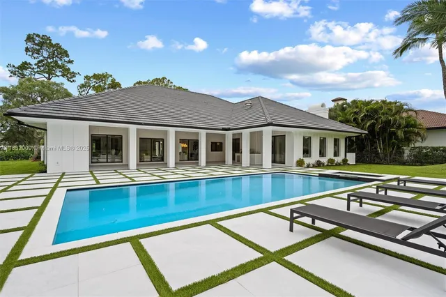 an aerial view of residential houses with outdoor space and lake view