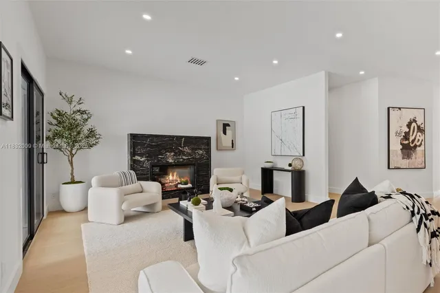 a living room with furniture a potted plant and a large window