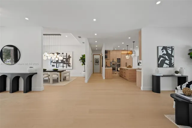 a kitchen that has a lot of white cabinets and stainless steel appliances