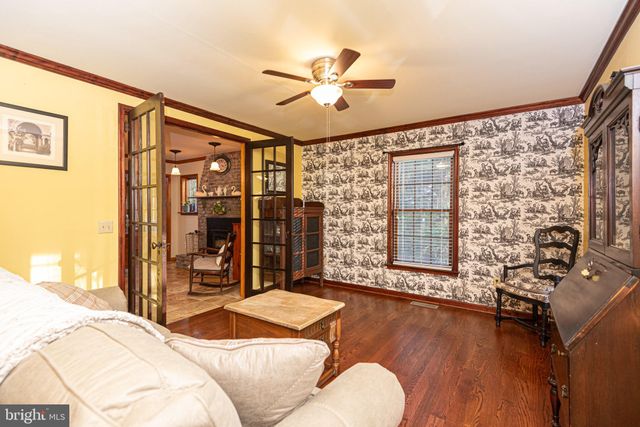 a view of a livingroom with furniture a fireplace a chandelier and wooden floor