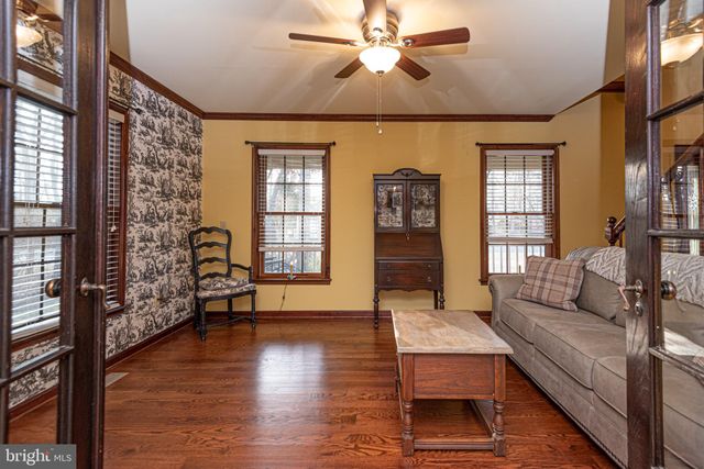 a living room with furniture large windows a flat screen tv and windows