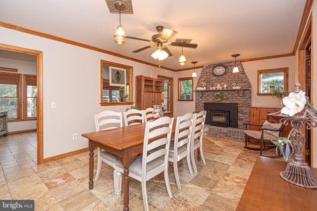 a kitchen with stainless steel appliances kitchen island granite countertop a refrigerator a stove a sink and white cabinets with wooden floor