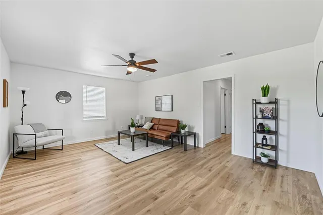 a living room with furniture and a wooden floor