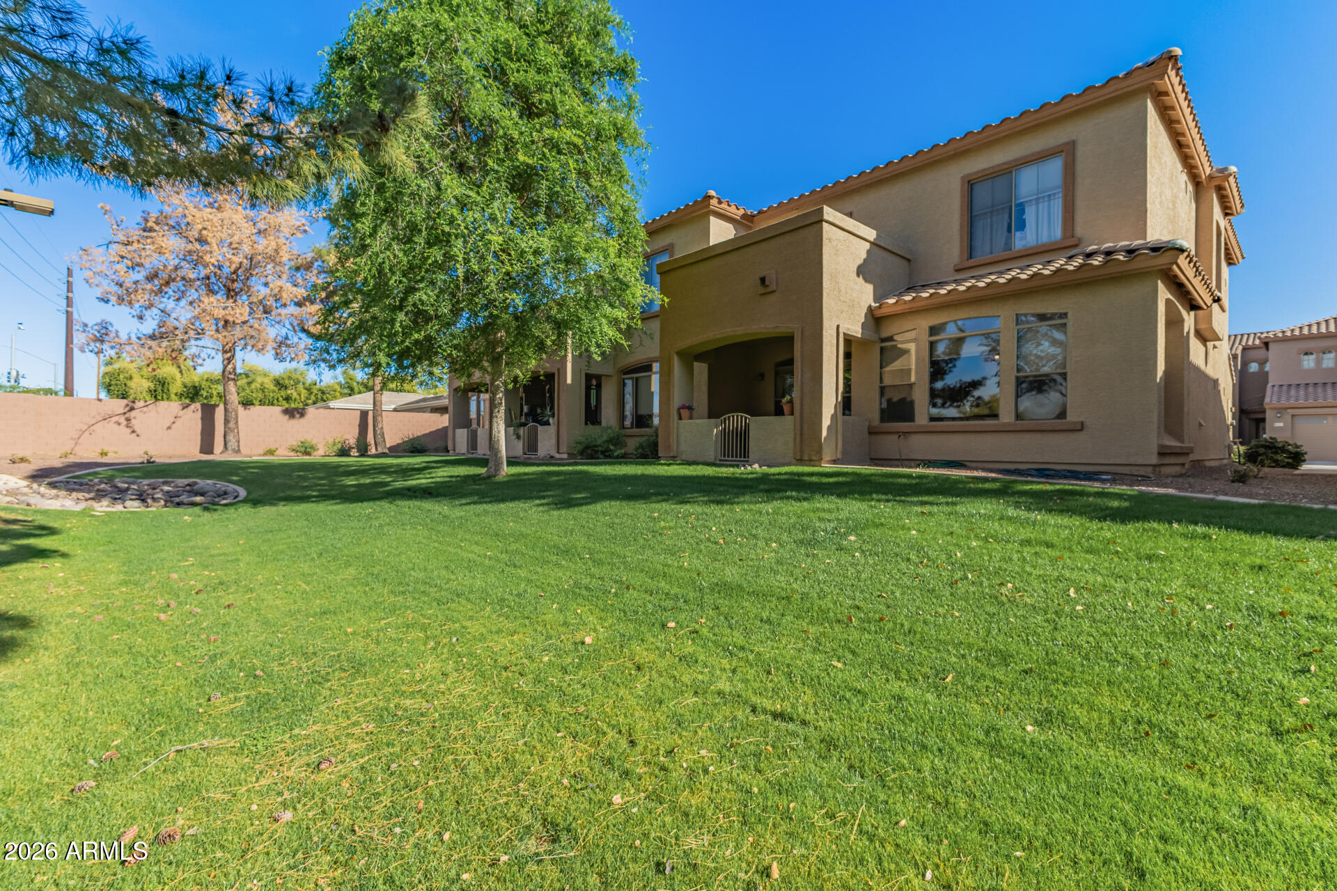 2600 East Springfield Place, Unit 34 Chandler, AZ 85286 - Photo 30 of 38 a view of a big house with a big yard and large trees