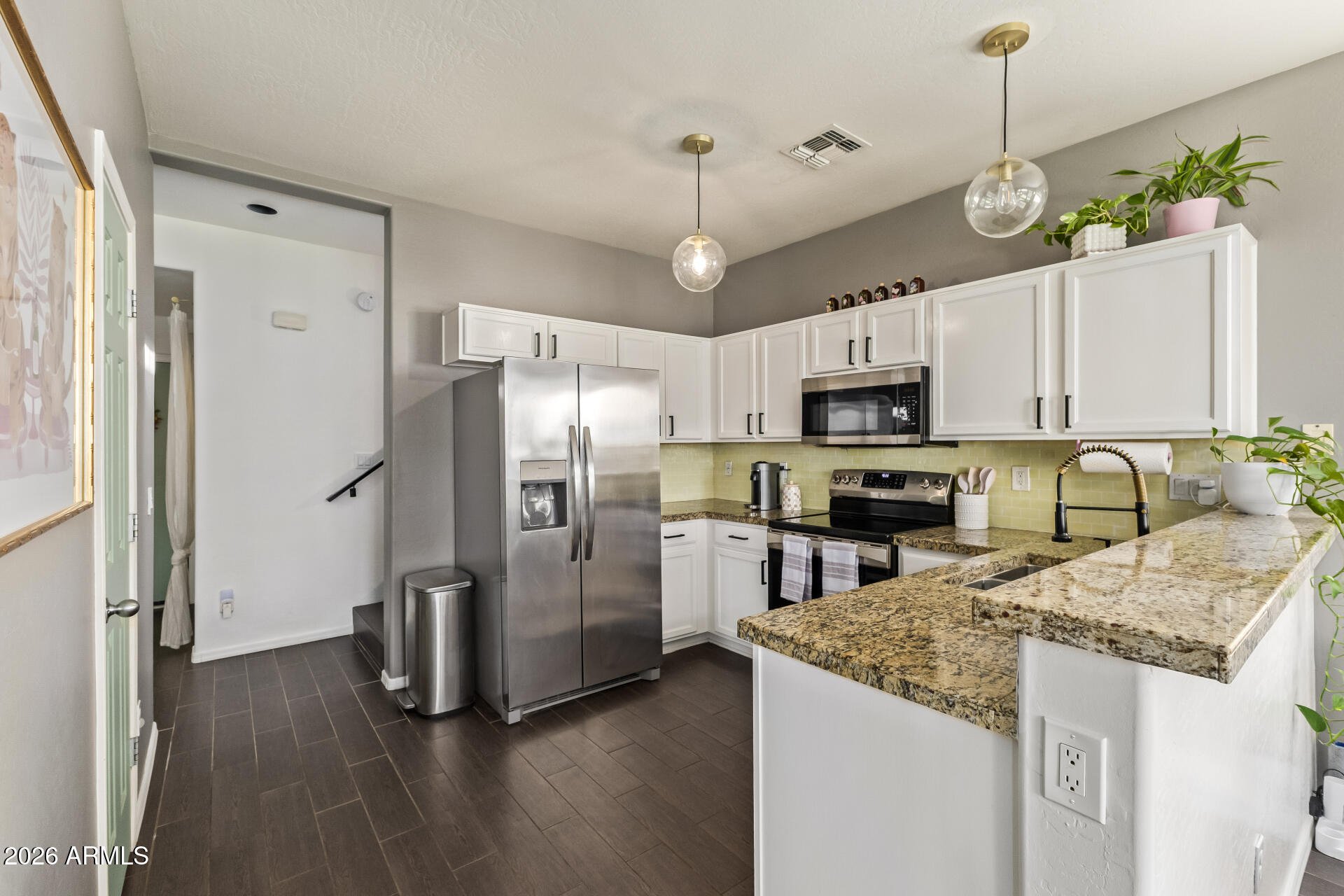 2600 East Springfield Place, Unit 34 Chandler, AZ 85286 - Photo 6 of 38 a kitchen with granite countertop a refrigerator a sink dishwasher a oven a dining table and chairs with wooden floor