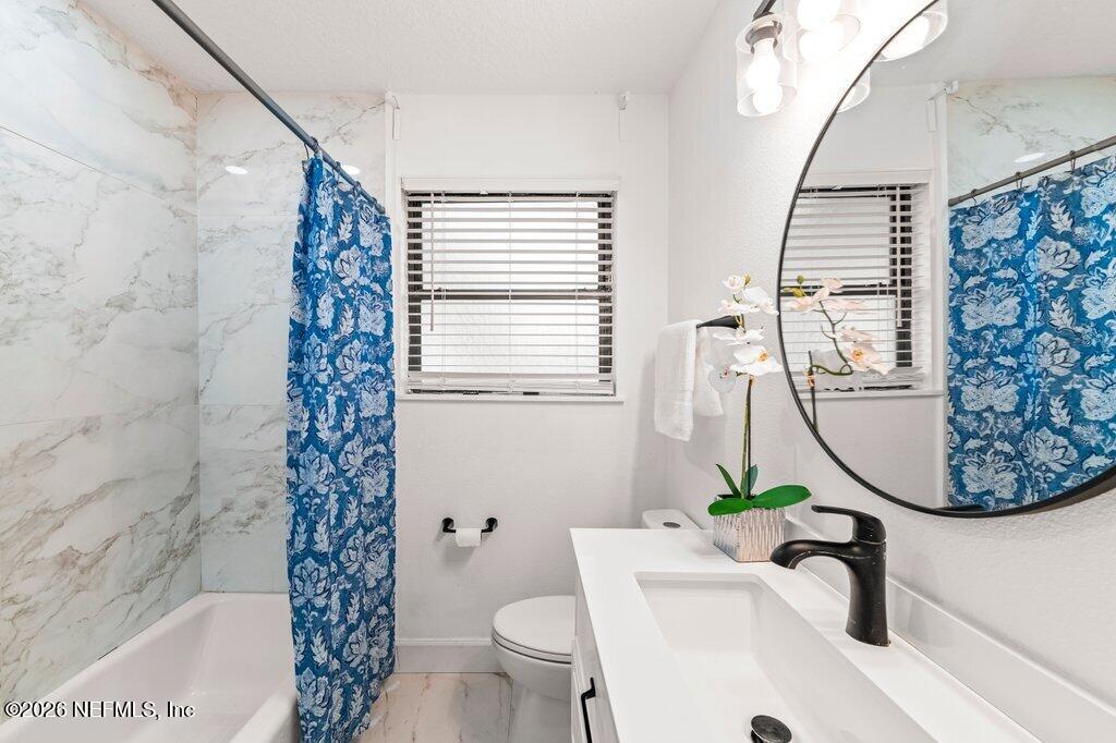 6731 Sans Souci Road Jacksonville, FL 32216 - Photo 19 of 27 a bathroom with a sink a toilet and a mirror