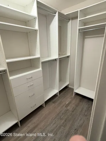 a view of walk in closet with empty racks